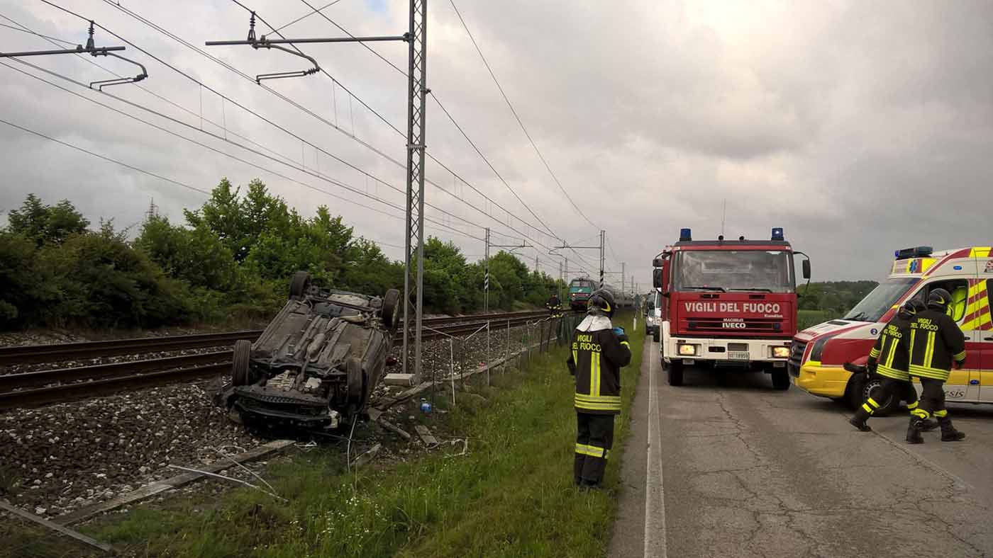 SI ROVESCIA CON L’AUTO SUI BINARI DELLA FERROVIA